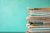 Stack of newspapers with teal copy space