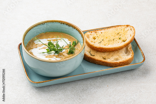 Portion of gourmet restaurant yellow pea soup with toast