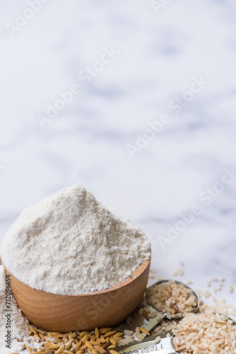 Organic white flour Thai in wooden bowl with white rice Thai and rice ears isolated on tone background, Food and baking ingredient, Healthy food concept, Top view.