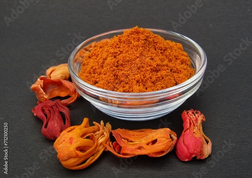 Mace spice powder in a glass bowl on black background side view 