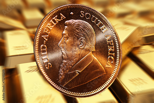 Nahaufnahme von eine Krügerrand Goldmünze, im Hintergrund unscharf Goldbarren (Composing) photo