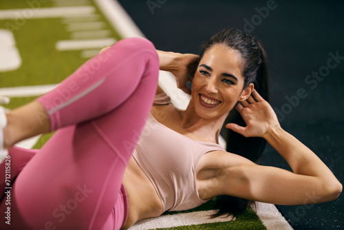 Tableau sur toile A sportswoman is doing side abs in a gym.