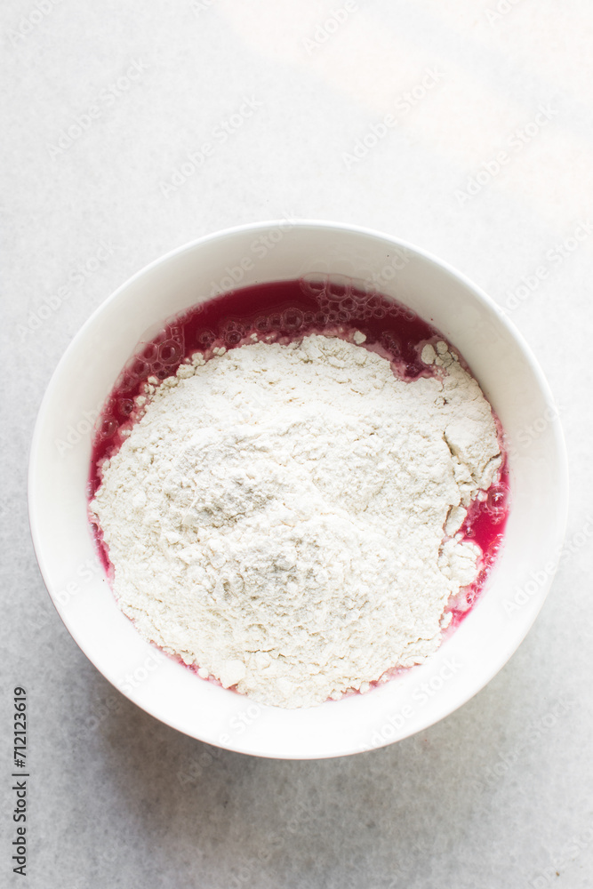 Beet Focaccia dough in a white bowl, process of making pink focaccia, beet dough rising in a white mixing bowl Beet Focaccia dough in a white bowl, process of making pink focaccia, beet dough rising in a white mixing bowl