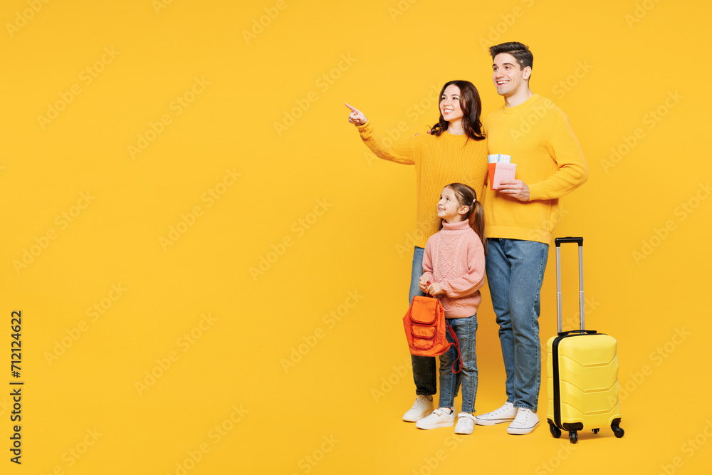 Traveler happy parents mom dad child kid girl wear casual clothes hold bag passport ticket isolated on plain yellow background. Tourist travel abroad in free time rest getaway Air flight trip concept Traveler happy parents mom dad child kid girl wear casual clothes hold bag passport ticket isolated on plain yellow background. Tourist travel abroad in free time rest getaway Air flight trip concept