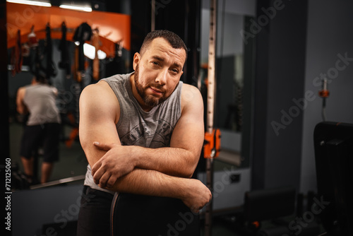 A large bearded man in the gym performs a squat exercise with a barbell. Preparation of a weightlifter for competitions Natural weight gain without the use of steroids. © Aboltin
