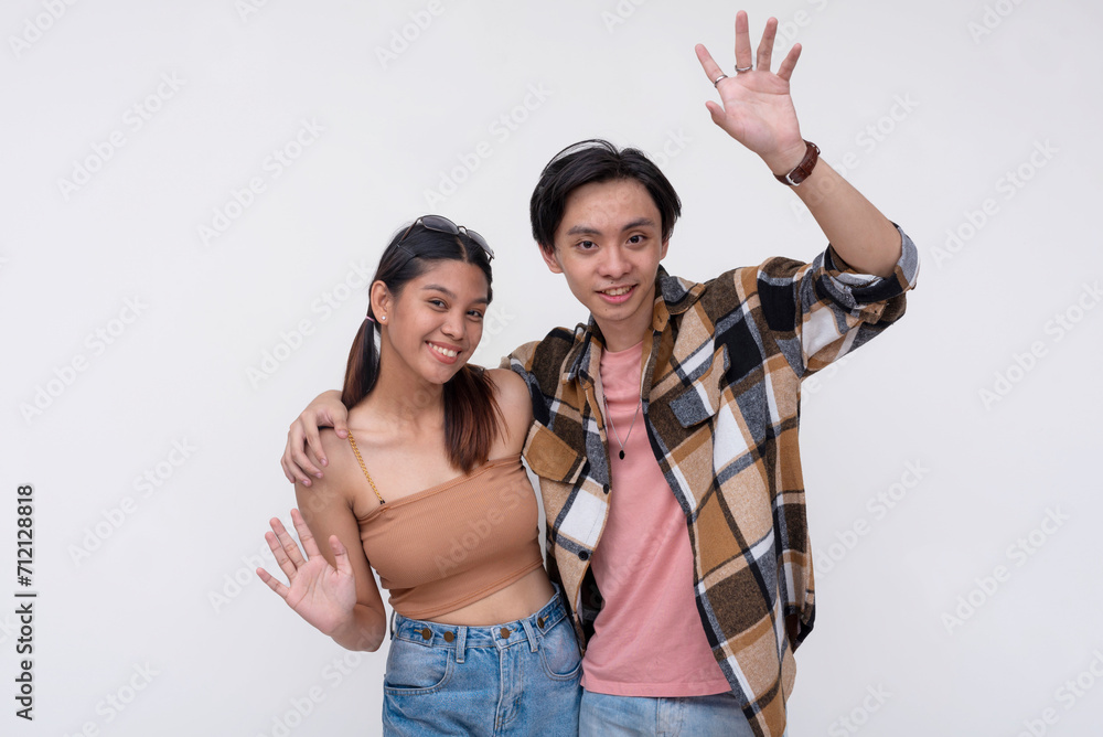 Cheerful young couple waving hands on white background Cheerful young couple waving hands on white background