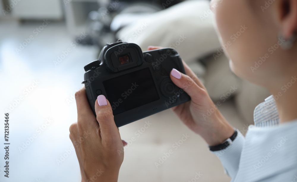Close-up of woman photographer go through pics on camera backstage after photoshot. Professional photographer, black device screen. Mockup, art concept Close-up of woman photographer go through pics on camera backstage after photoshot. Professional photographer, black device screen. Mockup, art concept