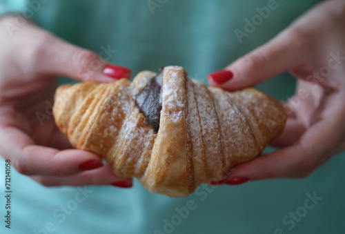 Person holds fresh tasty croissant with chocolate. Freshly made croissant recipe for healthy eating concept. Ingredients for French Baking.