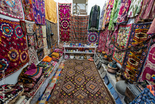 Variety of gorgeous oriental carpets in traditional carpet store in Middle East. Pile of beautiful handmade carpets on the traditional Middle East market bazaar. uzbek colorful carpets close-up photo