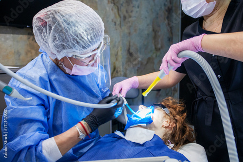 dental turbine handpiece in the hands of a dentist during dental treatment of a patient photo