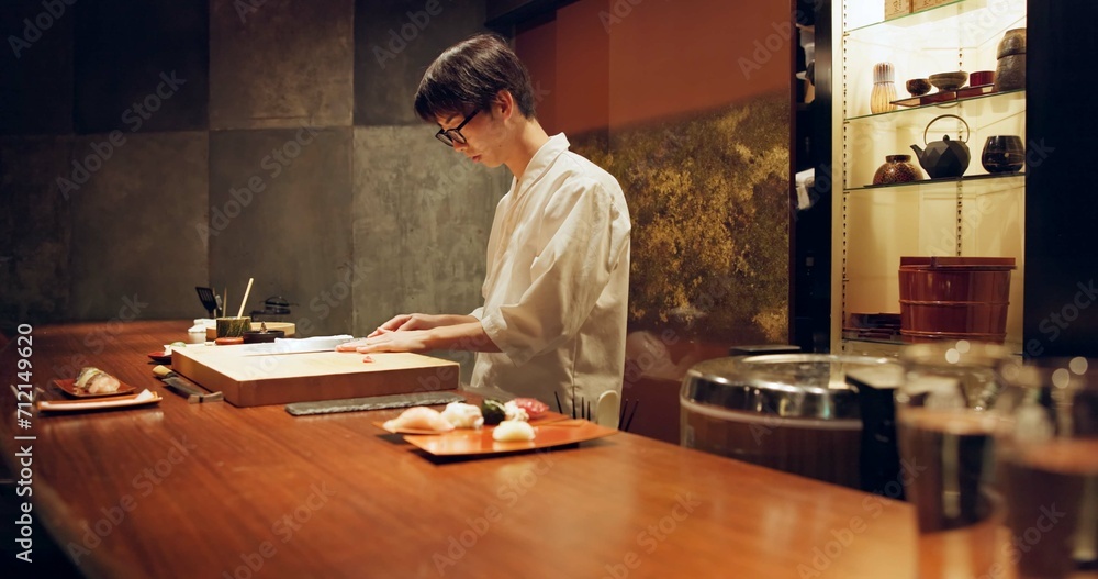 Chef, cooking and sushi in kitchen of restaurant for traditional food, cuisine or gourmet dish. Luxury, catering and salmon with Japanese man cook cutting fish for seafood meal ingredients or recipe Chef, cooking and sushi in kitchen of restaurant for traditional food, cuisine or gourmet dish. Luxury, catering and salmon with Japanese man cook cutting fish for seafood meal ingredients or recipe