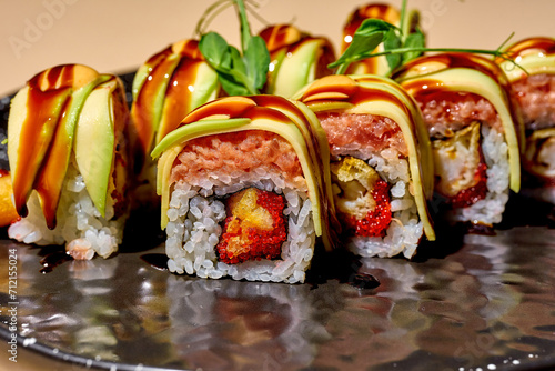 Sushi roll with tuna, shrimp and avocado on a bright background