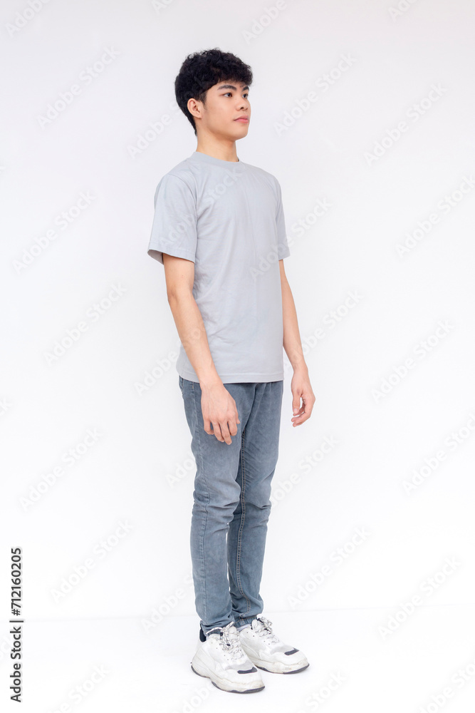 A confident young adult male stands in casual clothing with a neutral expression, 45 degree pose isolated on a white background. A confident young adult male stands in casual clothing with a neutral expression, 45 degree pose isolated on a white background.