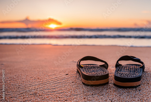 some sandals in the sand on a beach at sunset