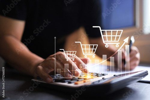 Revenue graph increase concept with entrepreneur using calculator to summary cost and profit shopping cart grow up in total sale for online store photo