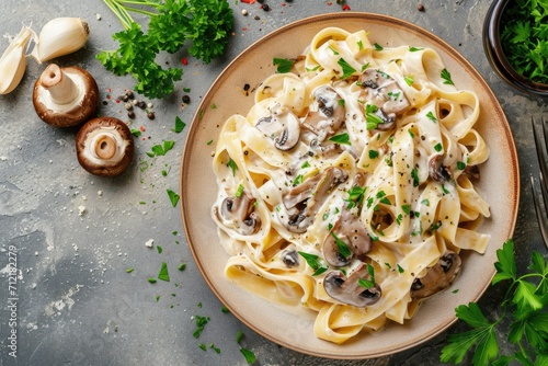 Overhead shot of mushroom pasta with cream sauce and parsley on a stone background photo