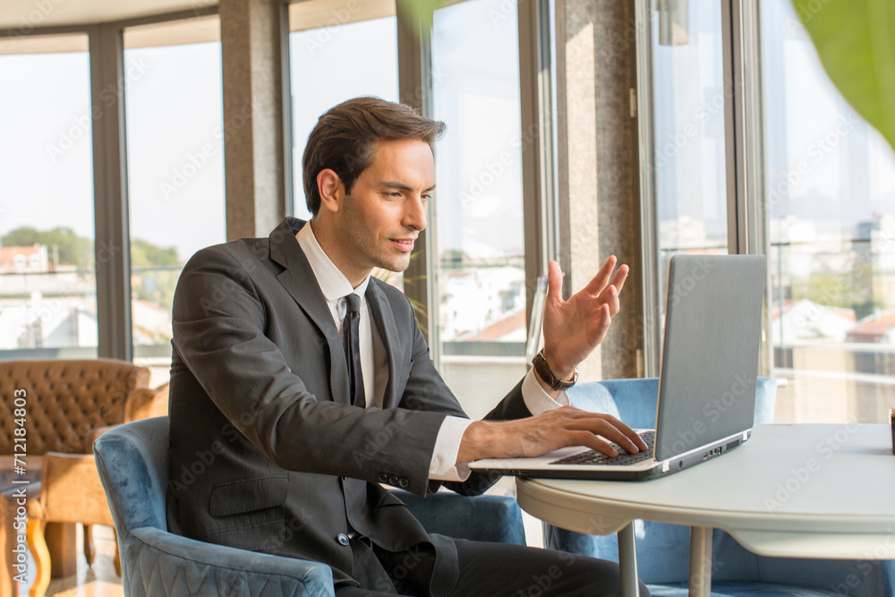 Fototapeta premium Businessman having video conversation in hotel cafe