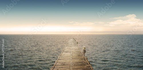 The sky gracefully descends to meet the sea, forming a breathtaking backdrop as bridges elegantly span the horizon. pier at sunset