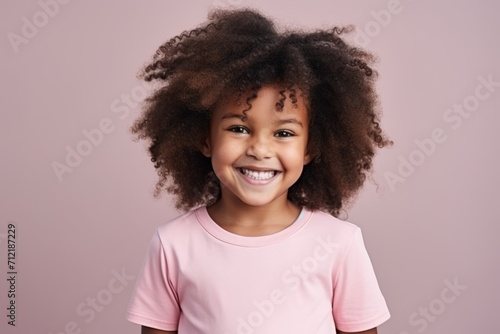 Portrait of a smiling african american little girl over pink background.