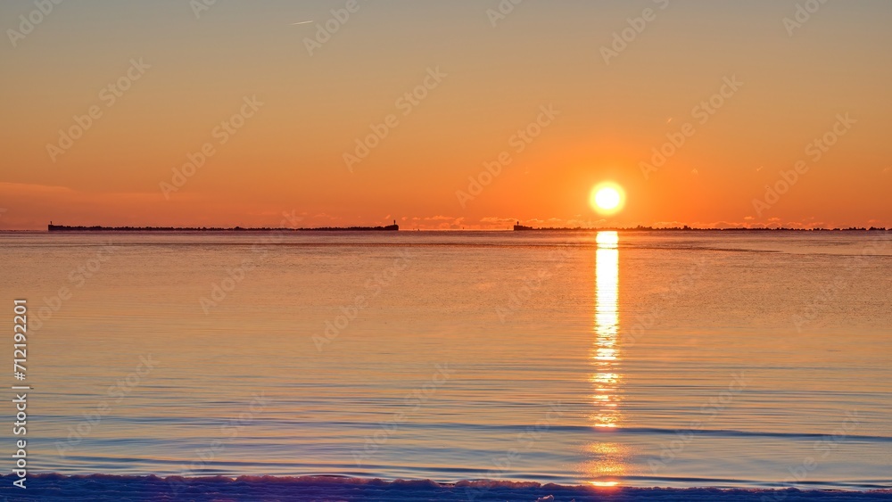 Winter Seascape. Sunrise over sea water. The sun rises above the horizon.