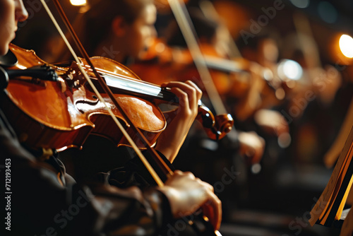An orchestral musician plays the violin in a symphony orchestra at a concert. Close-up