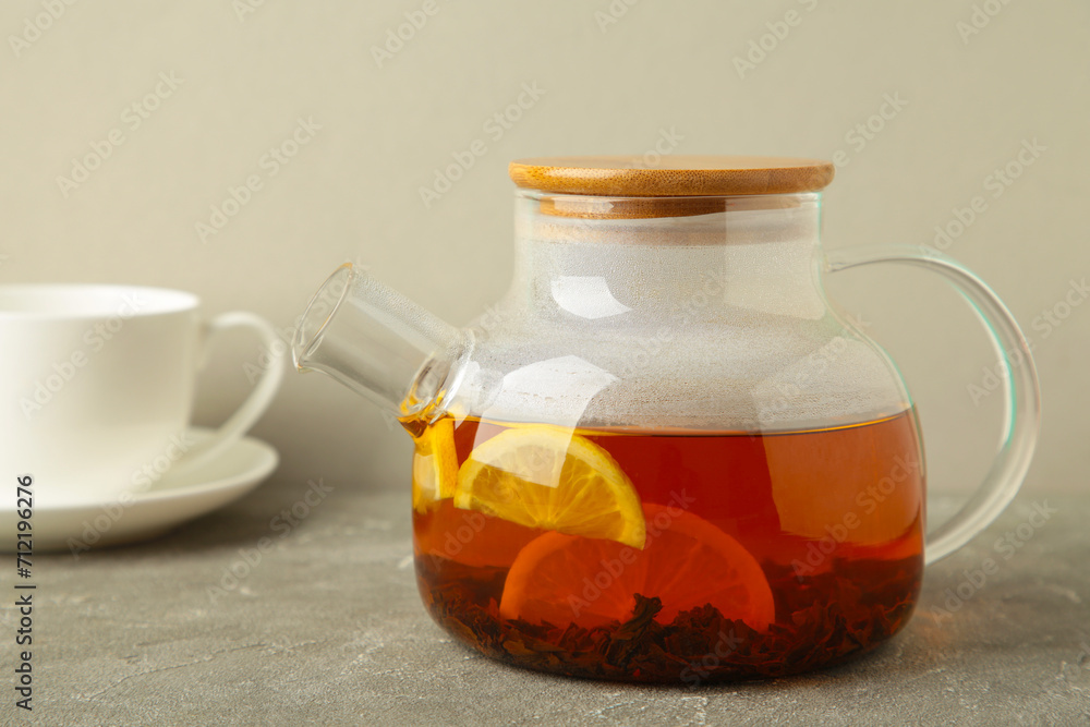 Glass teapot with tea and cup on grey background. Glass teapot with tea and cup on grey background.