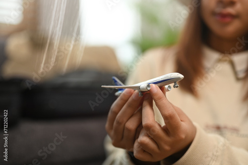 Closeup woman holding airplane model. Traveling, vacation and transportation concept