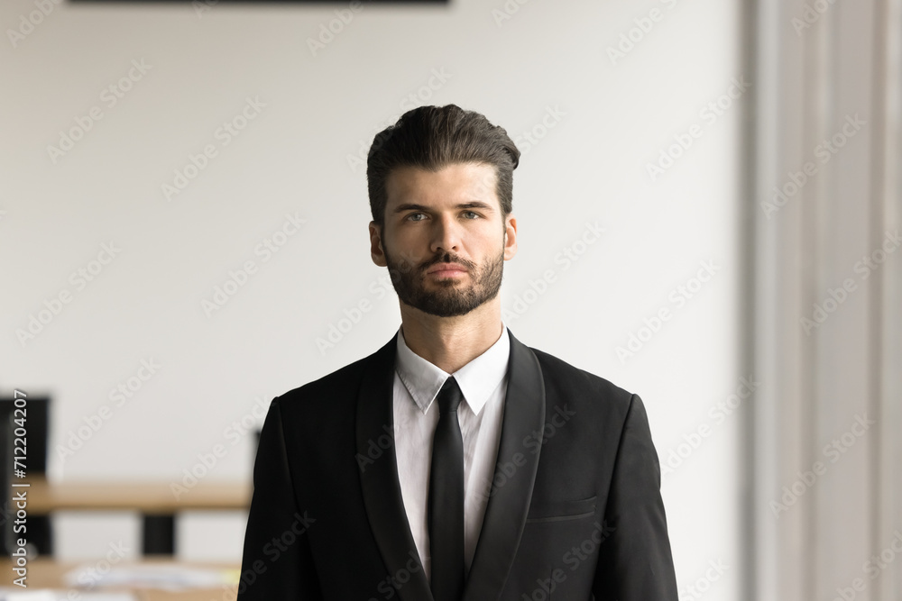 Serious handsome young executive man in formal suit and tie looking at camera. Confident businessman, CEO, lawyer, financial expert professional head shot portrait Serious handsome young executive man in formal suit and tie looking at camera. Confident businessman, CEO, lawyer, financial expert professional head shot portrait
