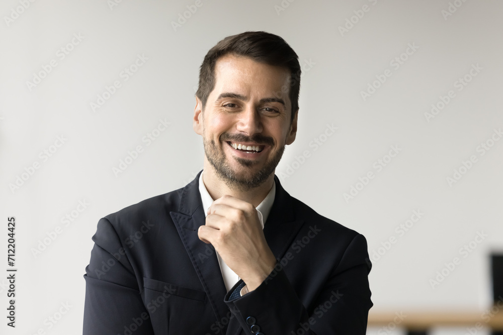 Cheerful handsome business executive man in formal suit looking at camera with toothy smile, touching bearded shin, laughing. Successful businessman, CEO, manager male head shot portrait Cheerful handsome business executive man in formal suit looking at camera with toothy smile, touching bearded shin, laughing. Successful businessman, CEO, manager male head shot portrait