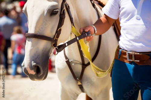 Unrecognizable male equestrian in white attire holding the reins of a white horse at a hippodrome © ADDICTIVE STOCK CORE