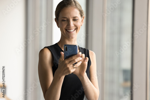 Free Download Cheerful attractive business leader woman typing on smartphone, using Internet application, professional service for job on mobile phone, enjoying online communication, wireless technology - GFXLoad