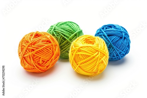 Four cotton thread balls colors orange yellow green blue isolated on white background