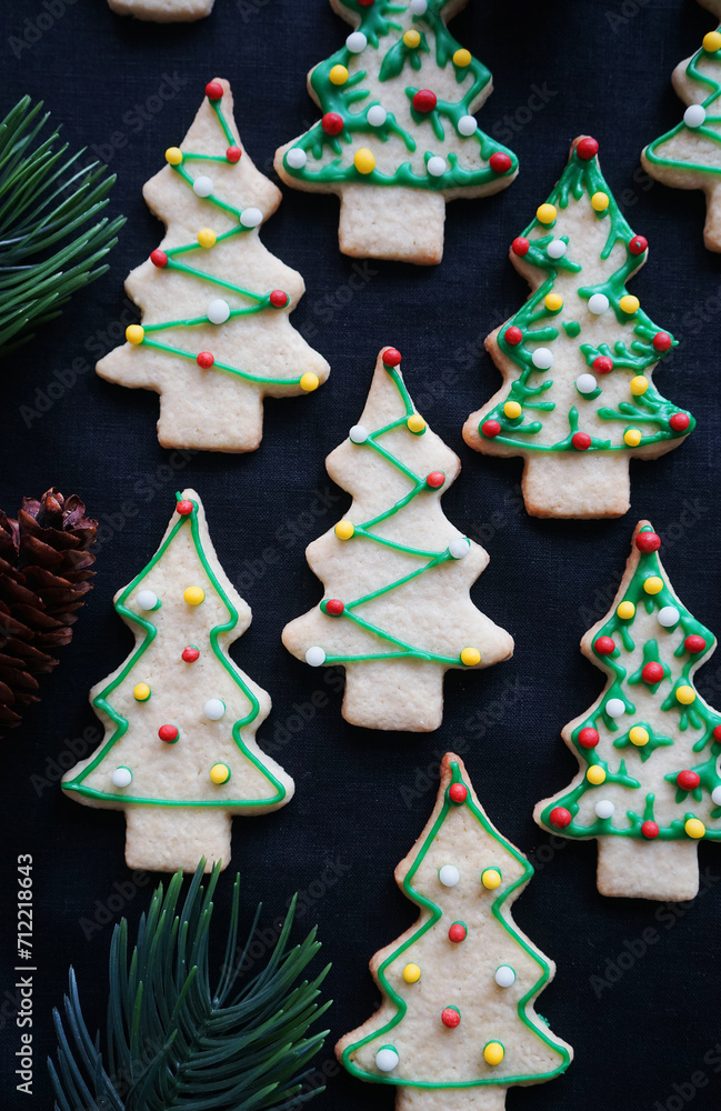 Cookies in the shape of a Christmas tree with green icing on a dark background Cookies in the shape of a Christmas tree with green icing on a dark background