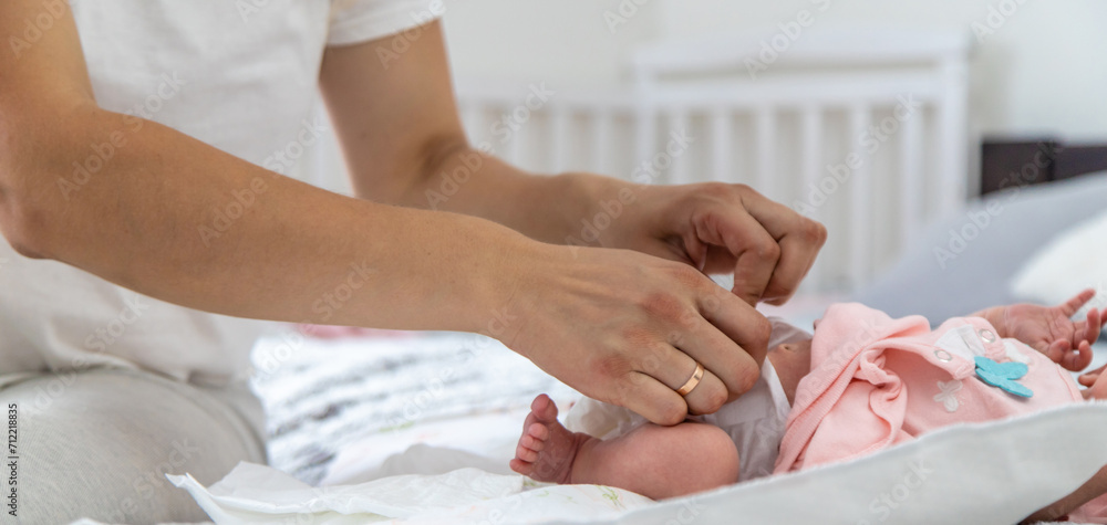 Obraz premium A mother changes her child's diaper, close-up.