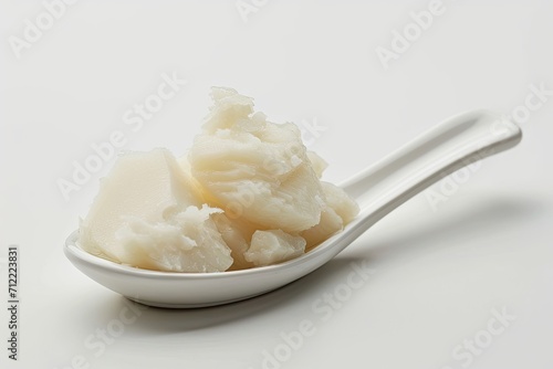 Solidified lard on white background in a spoonful photo