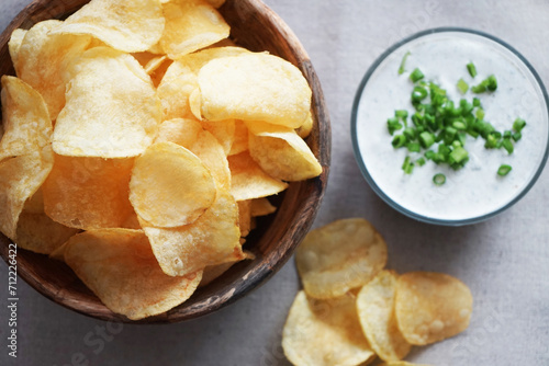 Potato chips with sauce with herbs on a gray background