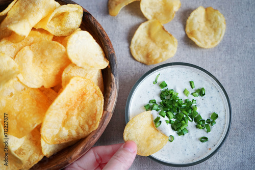 Potato chips with sauce with herbs on a gray background
