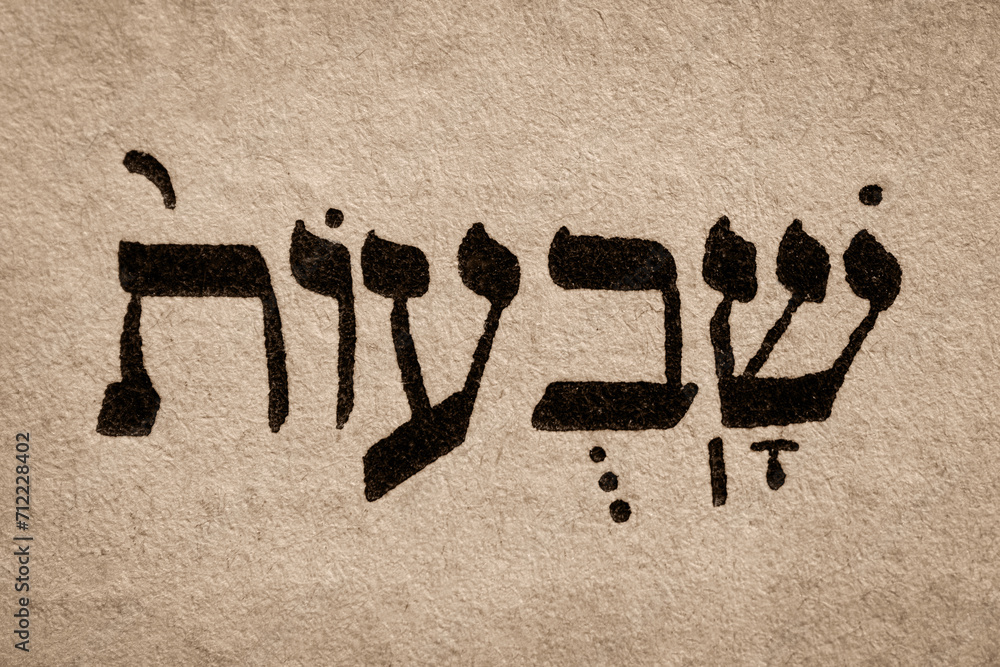 Single hebrew word Shavuot on page of old Torah book. English translation is Feast of Weeks. One of biblically-ordained Three Pilgrimage Festivals. Jewish holiday. Hebrew script. Closeup.