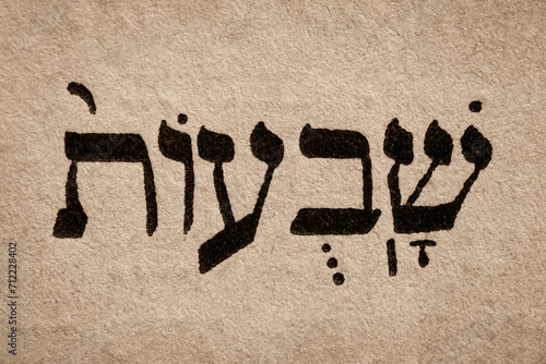 Obraz na płótnie Single hebrew word Shavuot on page of old Torah book. English translation is Feast of Weeks. One of biblically-ordained Three Pilgrimage Festivals. Jewish holiday. Hebrew script. Closeup. w salonie