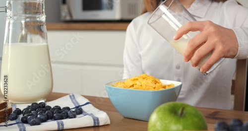 Child carefully pours vegan milk into cereal perfect vegan breakfast. Vegan breakfast slow and serene start of school day Each piece in vegan breakfast symbolizes healthy conscious choice.