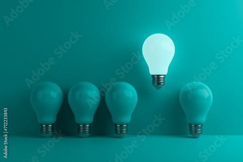 Glowing lamp stands out from other lamps on a turquoise background. Concept of innovation, solutions, uniqueness, individuality and thinking differently. 3d rendering.