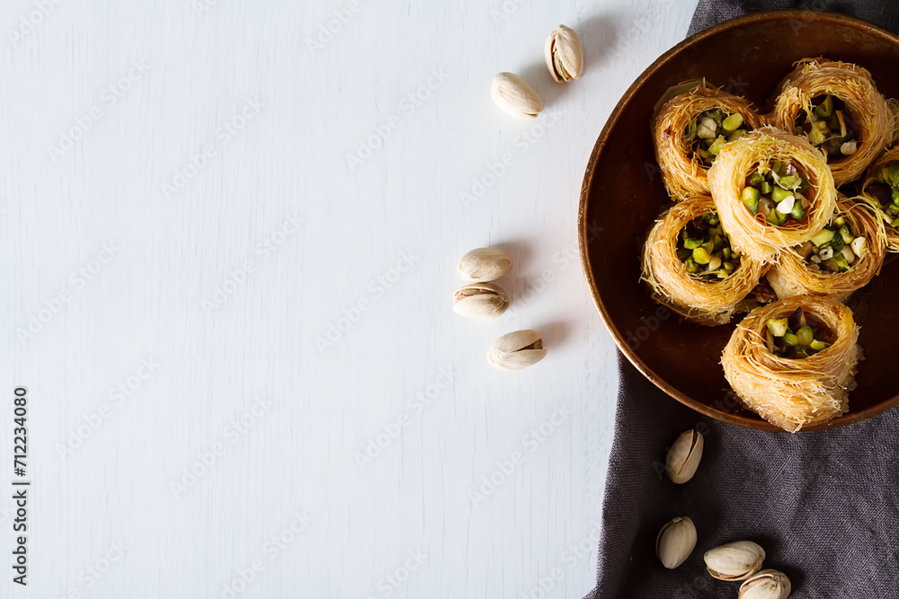 Traditional arabic dessert baklava with pistachios. White background - obrazy, fototapety, plakaty 