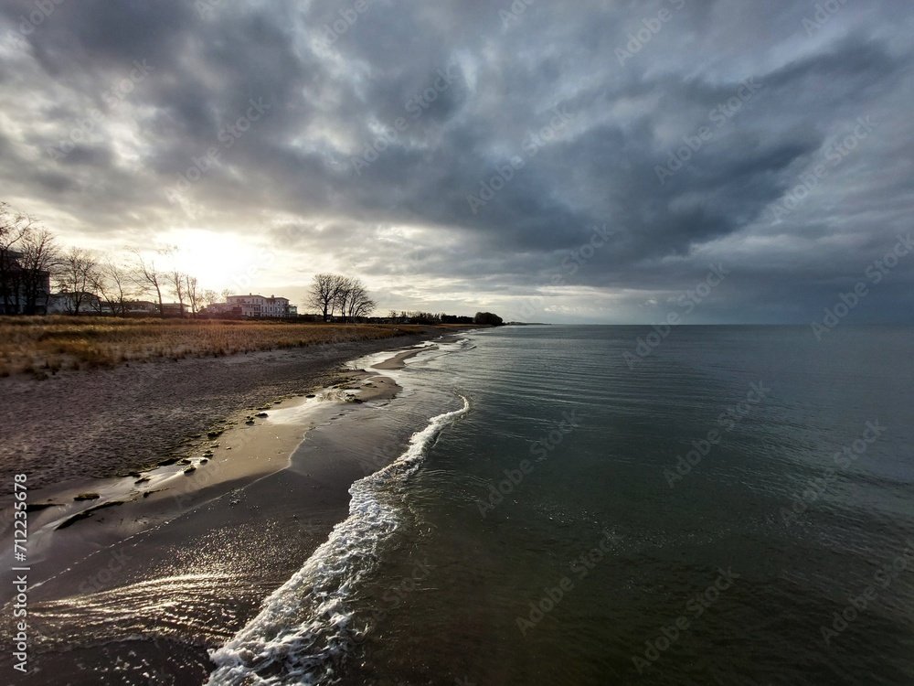 The sun is breaking through clouds at the beach of the Baltic Sea in Lubmin