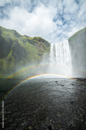 Long exposure view of famous Skogafoss waterfall with colourful sky and double rainbow. Magnificent Iceland in august. Fimmvörðuháls Hiking Trail. Popular Travel destinations