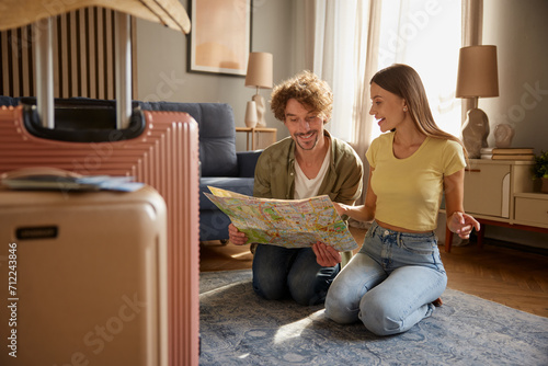 Preparation for vacation concept with happy spouses searching travel rout in map