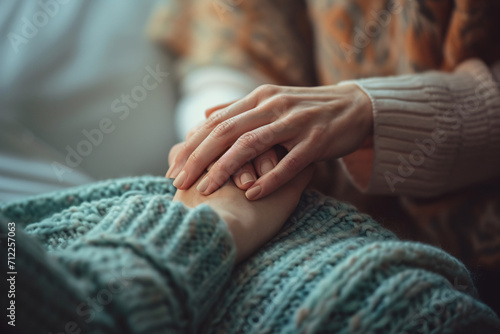 A woman compassionately holding the hand of a another woman close-up