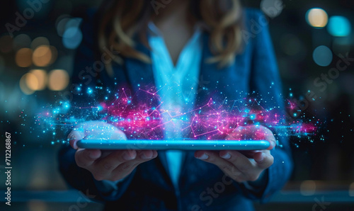 Business woman wearing suit hand holding tablet overlay with digital blue and pink hologram data. photo