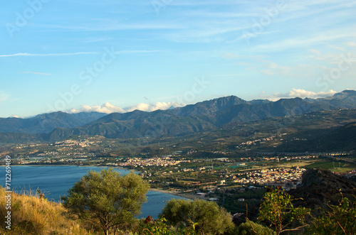 Fototapeta Naklejka Na Ścianę i Meble -  Picturesque aerial landscape view of Tindary at sunny autumn day. City on the shore of The Mediterranean Sea. Majestic mountains in the background. Travel and tourism concept
