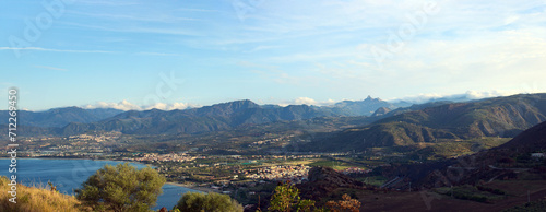 Panoramic aerial landscape view of Tindary at sunny autumn day. City on the shore of The Mediterranean Sea. Majestic mountains in the background. Travel and tourism concept photo