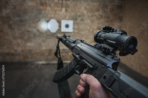 Shooting at a target from a tactical carbine with an optical sight. Photo with a first-person view. photo